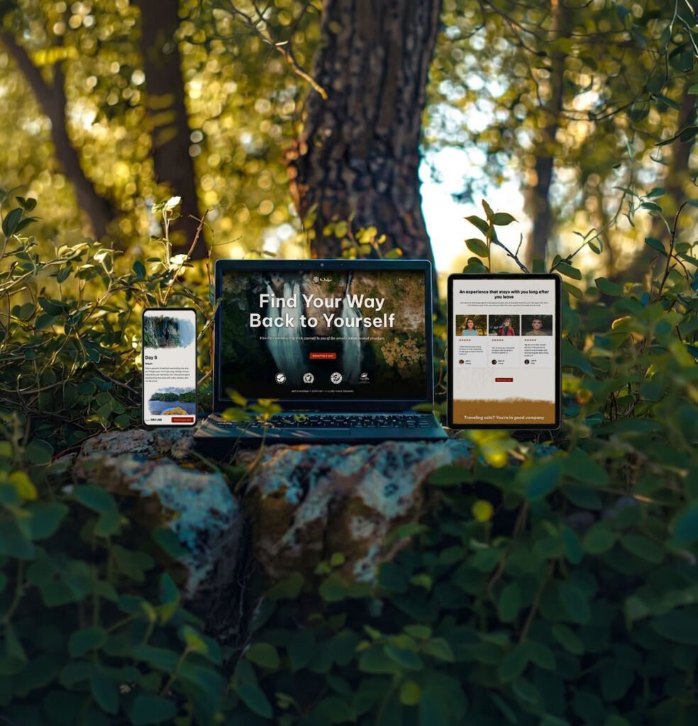Responsive mockup of the Nido wellness retreat landing page design across phone, laptop, and tablet in a forest setting