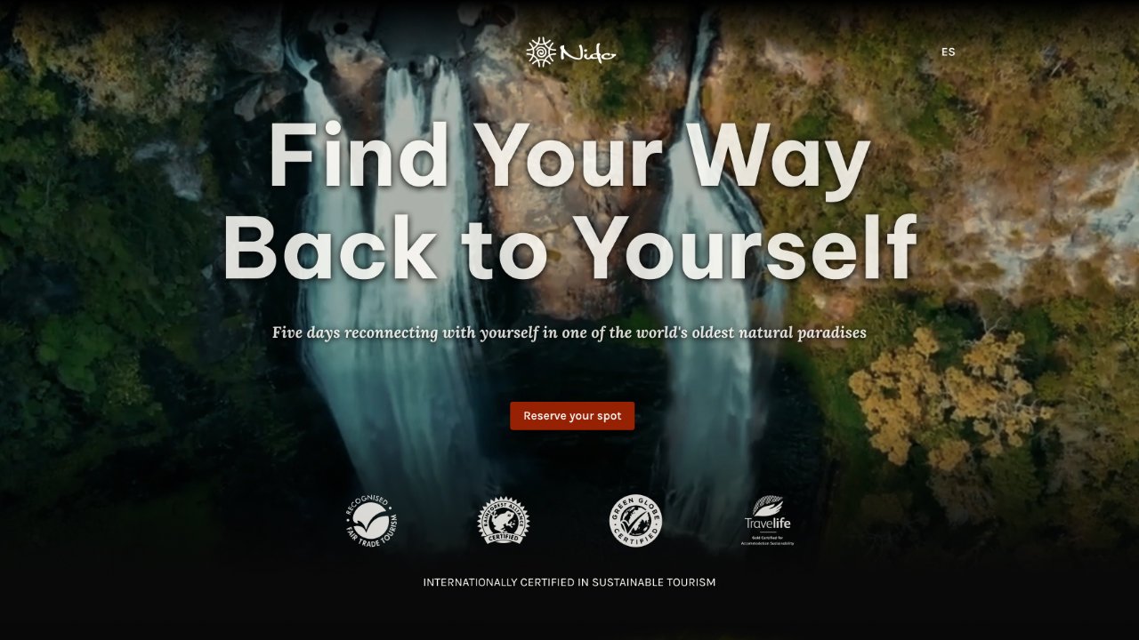 Full-screen hero section of a wellness retreat landing page design featuring a waterfall and a single call-to-action button